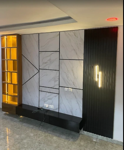 Lensartic feature wall with marble-effect panels, dark vertical joinery and warm illuminated shelving