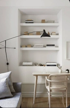 Compact white home office with open shelving, a timber desk and black task lamp