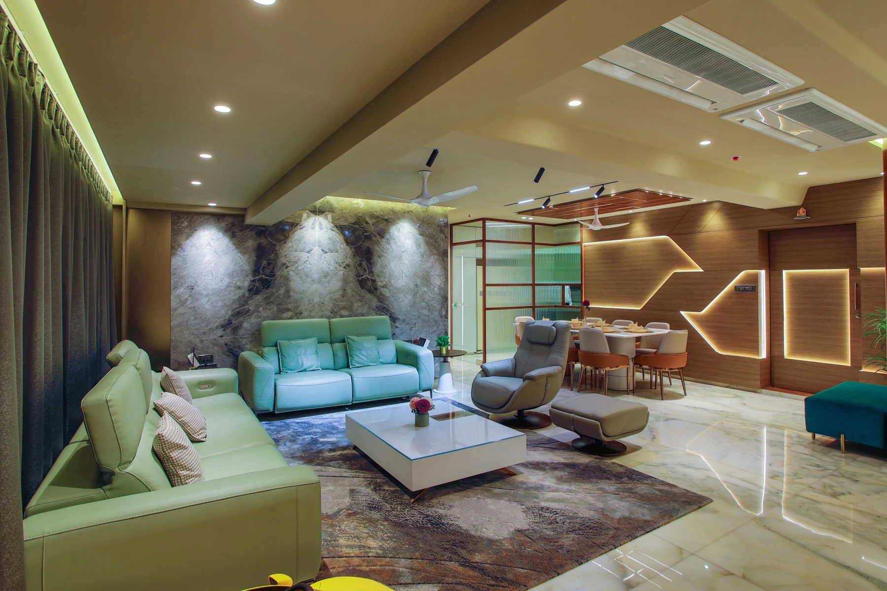 A spacious living room with marble floors, upholstered sofas and warm ambient lighting